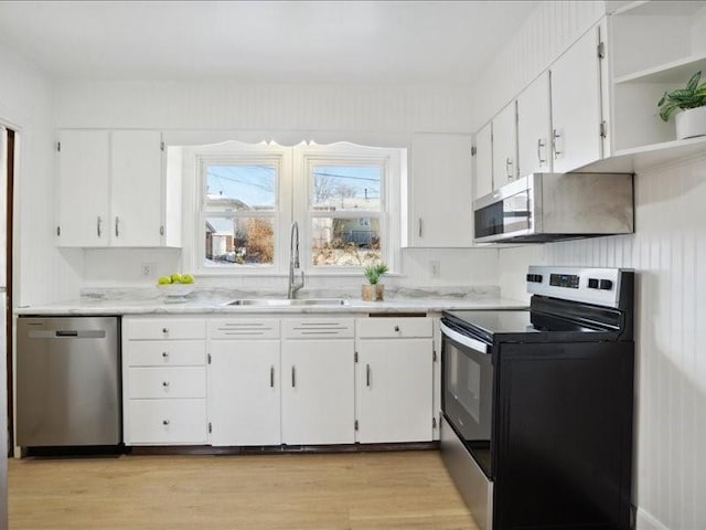 kitchen featuring sink, white cabinets, light wood-type flooring, and appliances with stainless steel finishes