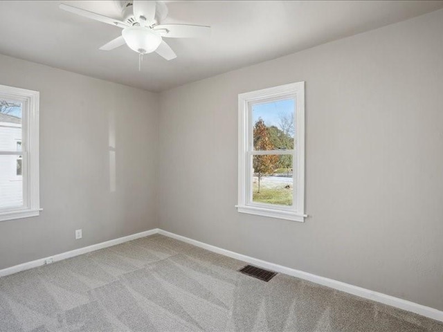 unfurnished room with ceiling fan, light carpet, and a wealth of natural light