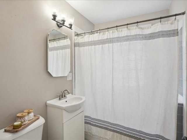 bathroom with a shower with shower curtain, vanity, and toilet