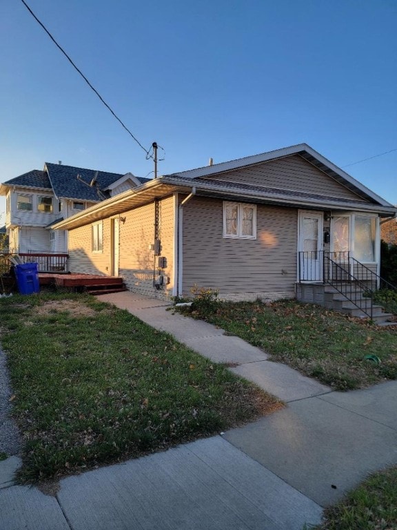 view of front facade with a front lawn and a wooden deck