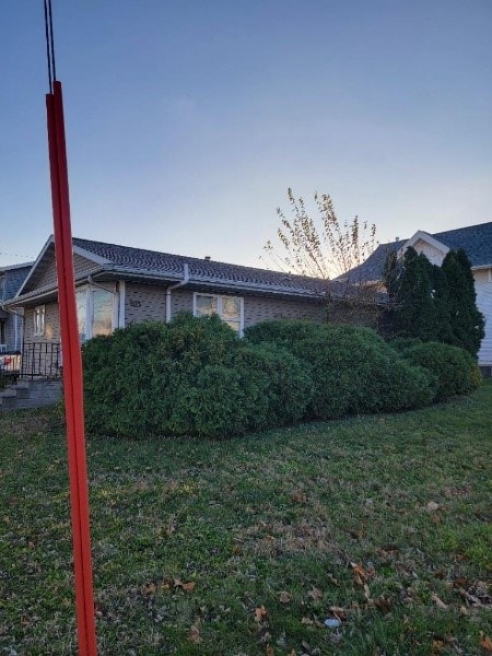 property exterior at dusk with a yard