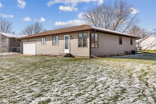 view of front of property featuring central AC, a front lawn, and a garage