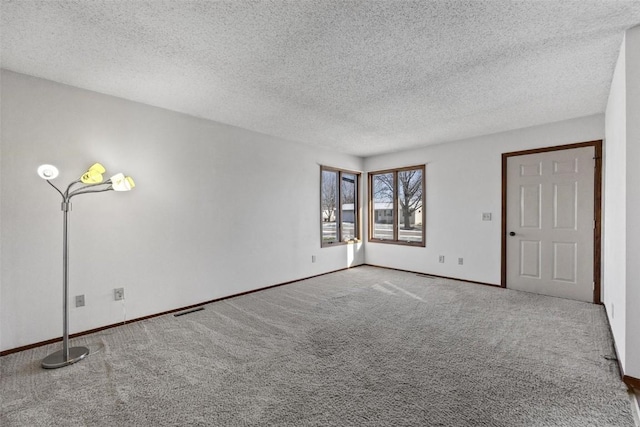 carpeted empty room with a textured ceiling