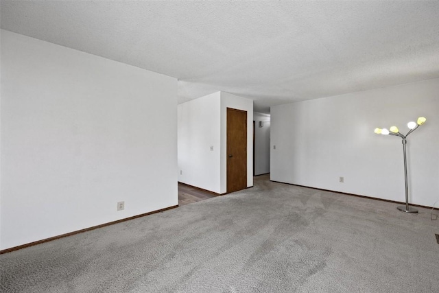 empty room featuring dark carpet and a textured ceiling