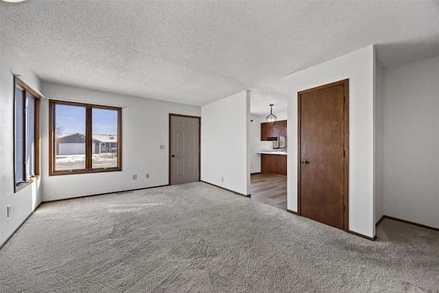 carpeted empty room featuring a textured ceiling