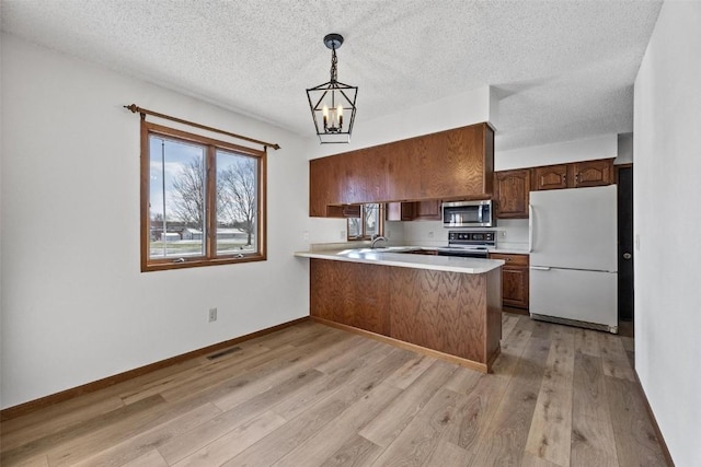 kitchen with kitchen peninsula, pendant lighting, white refrigerator, electric range, and light hardwood / wood-style floors