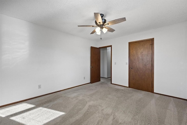 unfurnished bedroom with ceiling fan, light carpet, and a textured ceiling