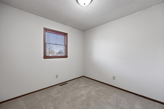 unfurnished room with a textured ceiling and light carpet