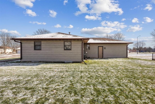 rear view of property featuring a lawn