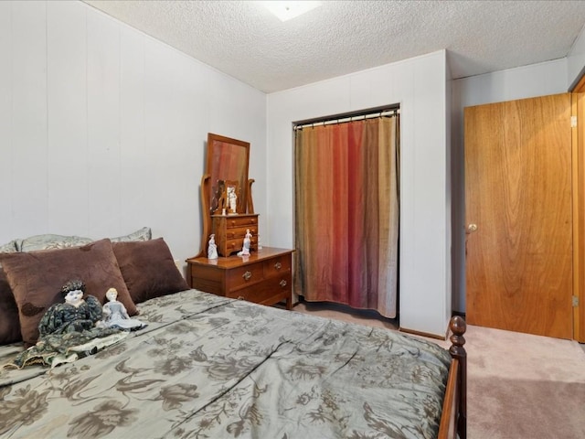 carpeted bedroom featuring a textured ceiling and a closet