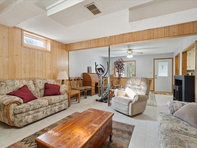 living room with ceiling fan and wooden walls