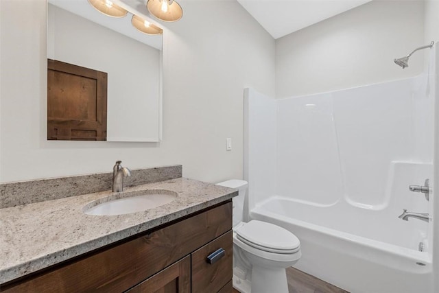 full bathroom featuring shower / washtub combination, hardwood / wood-style floors, vanity, and toilet