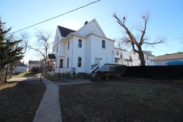 back of property featuring a yard and a wooden deck