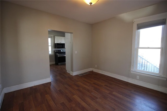 unfurnished room with dark wood-type flooring