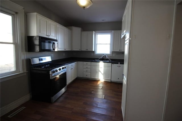 kitchen featuring white cabinetry, stainless steel range, dark hardwood / wood-style floors, and sink