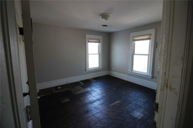 empty room featuring dark hardwood / wood-style floors and a healthy amount of sunlight