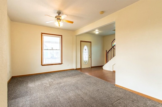 foyer featuring dark carpet and ceiling fan