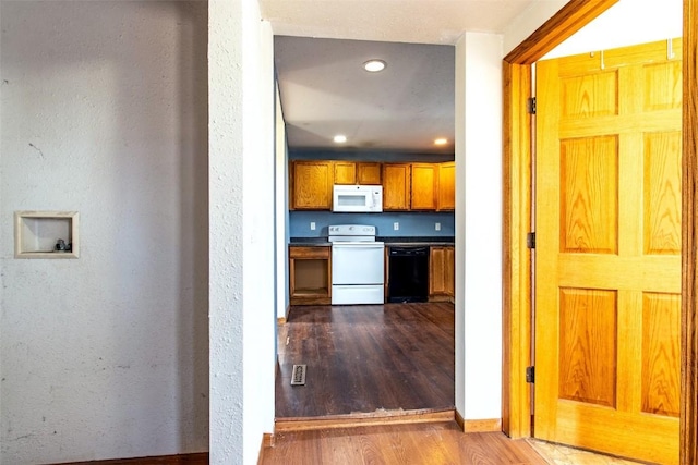 kitchen with white appliances and hardwood / wood-style flooring