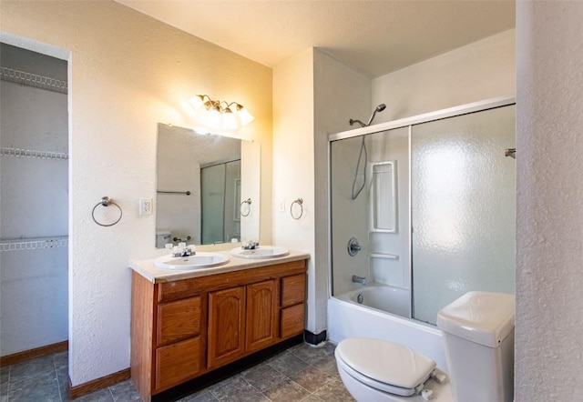 full bathroom featuring toilet, combined bath / shower with glass door, and vanity