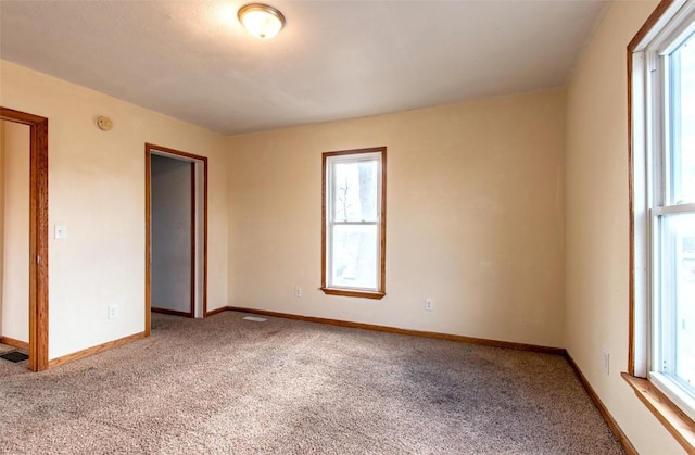 empty room with carpet floors and a healthy amount of sunlight