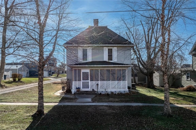 view of front facade with a front lawn and a sunroom