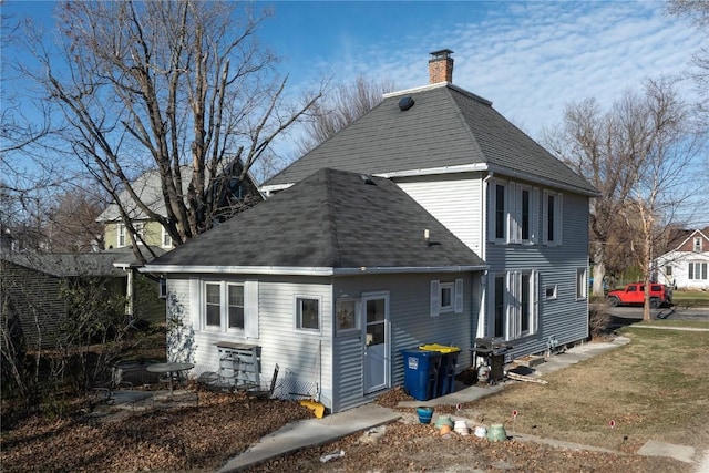 rear view of house featuring a lawn