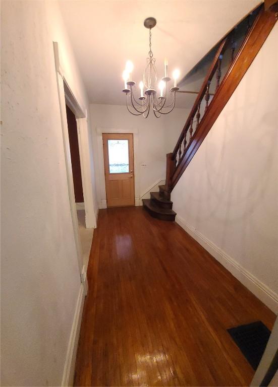 doorway to outside featuring hardwood / wood-style floors and a notable chandelier