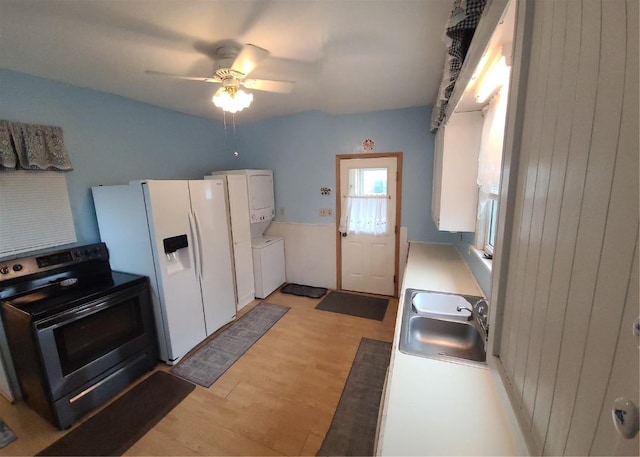 kitchen featuring sink, stacked washing maching and dryer, electric range, white fridge with ice dispenser, and white cabinets