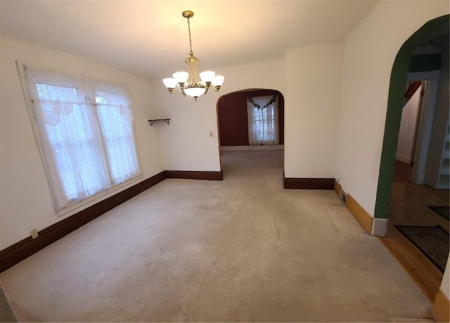 unfurnished dining area featuring an inviting chandelier and carpet