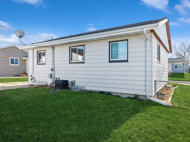 back of property featuring cooling unit and a lawn