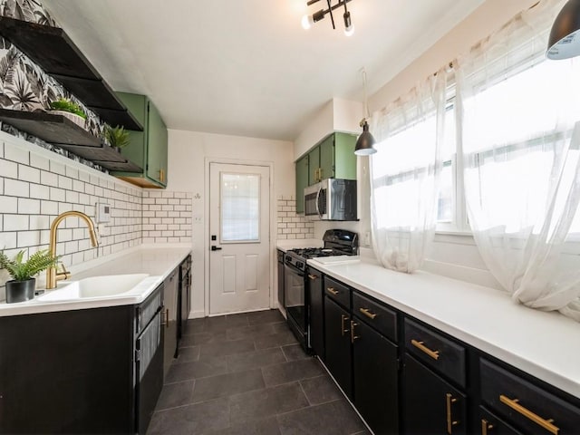 kitchen with a wealth of natural light, green cabinets, sink, and appliances with stainless steel finishes