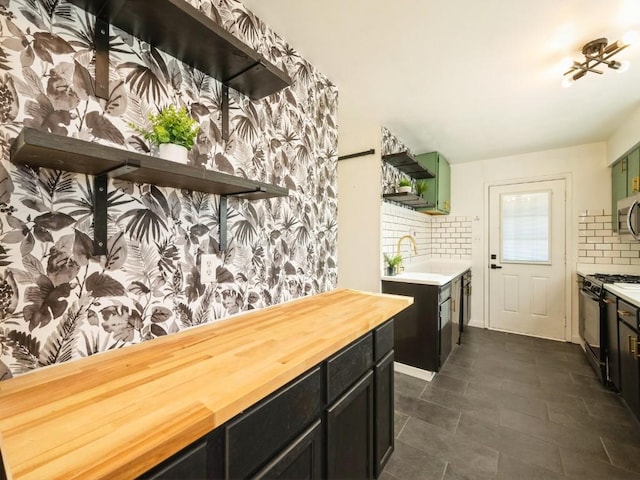 kitchen featuring backsplash, sink, range with gas stovetop, and wooden counters