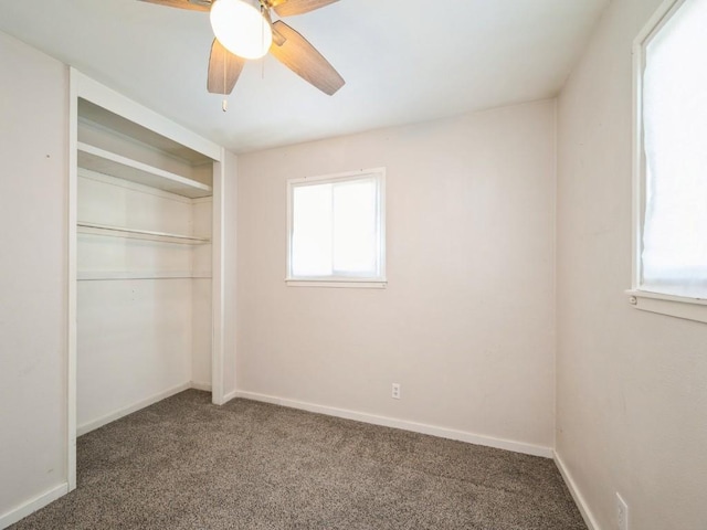 unfurnished bedroom with ceiling fan, dark carpet, and a closet