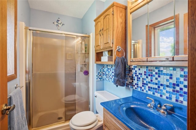 bathroom featuring vanity, toilet, decorative backsplash, and walk in shower