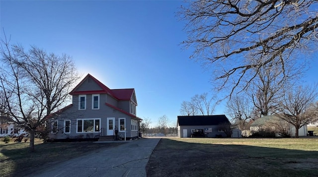 view of front of house featuring an outdoor structure and a front lawn