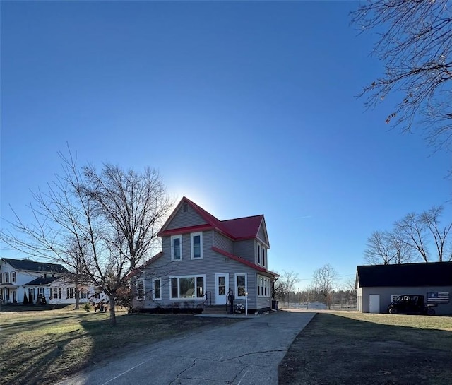 victorian home featuring a front yard and an outbuilding