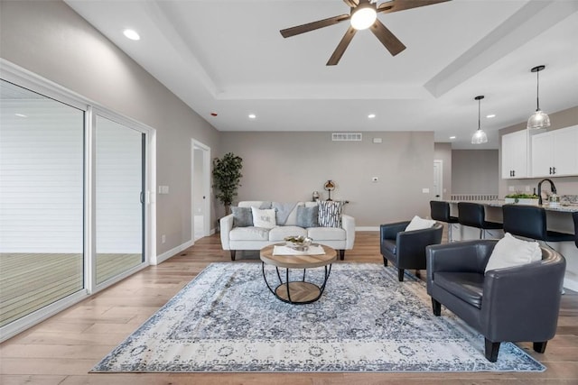 living room featuring light hardwood / wood-style flooring and ceiling fan