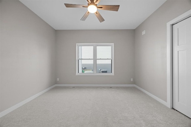 spare room with ceiling fan and light colored carpet