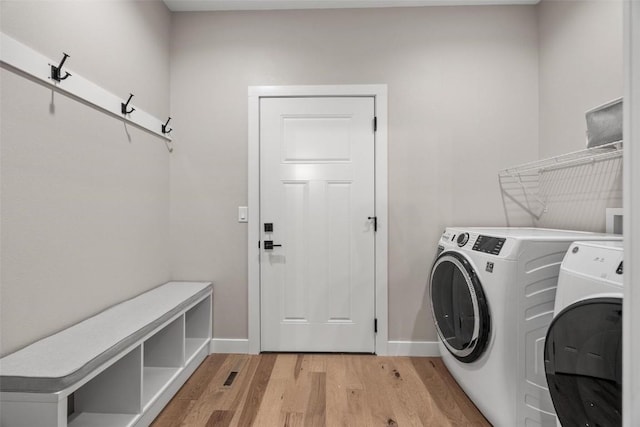 washroom featuring washer and clothes dryer and light wood-type flooring