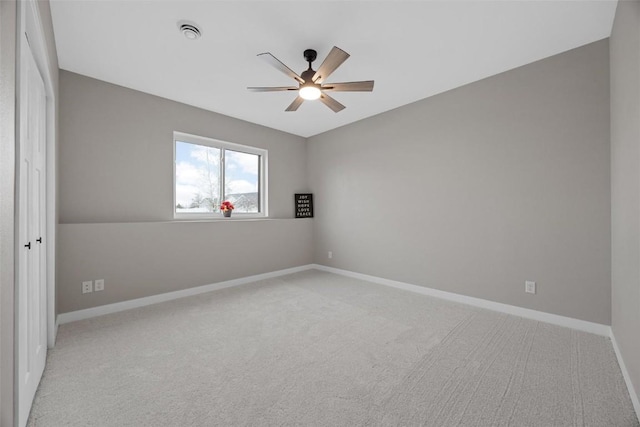 spare room featuring ceiling fan, light colored carpet, and lofted ceiling