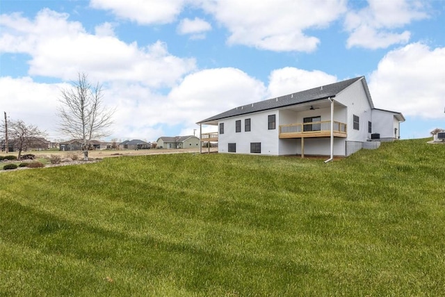 back of property featuring a yard, a deck, and ceiling fan