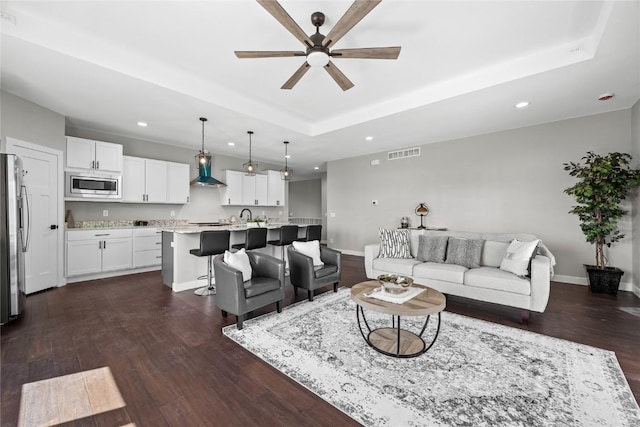 1596 Connection Ave, Marion, IA 52302 - living area featuring a tray ceiling, a ceiling fan, recessed lighting, dark wood-style floors, and baseboards
