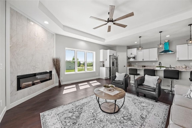 1596 Connection Ave, Marion, IA 52302 - living area featuring a raised ceiling, dark wood finished floors, ceiling fan, recessed lighting, and baseboards