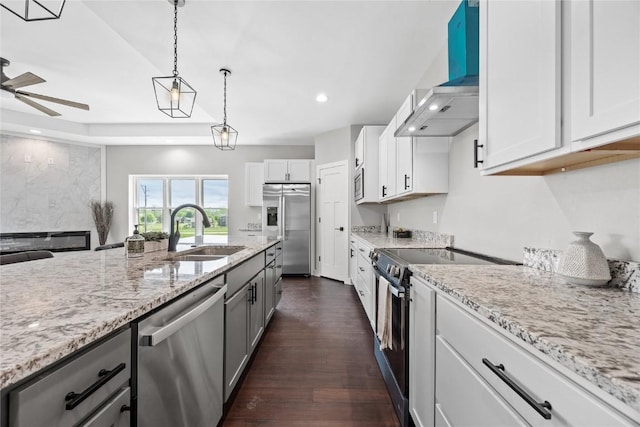 1596 Connection Ave, Marion, IA 52302 - kitchen featuring appliances with stainless steel finishes, wall chimney range hood, a sink, a ceiling fan, and light stone counters