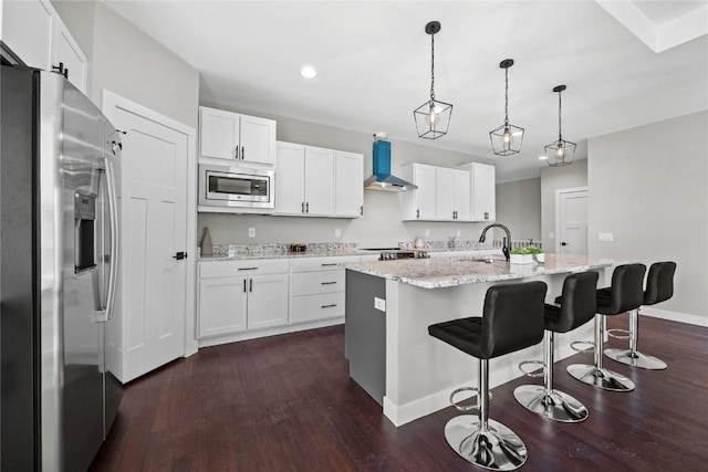 1596 Connection Ave, Marion, IA 52302 - kitchen featuring appliances with stainless steel finishes, wall chimney range hood, dark wood-style flooring, white cabinets, and recessed lighting
