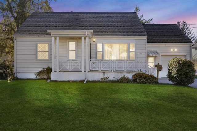 view of front of home with a garage and a yard