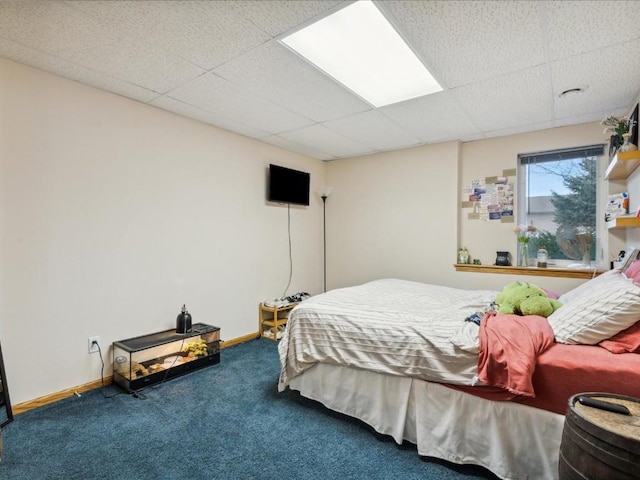 carpeted bedroom featuring a drop ceiling