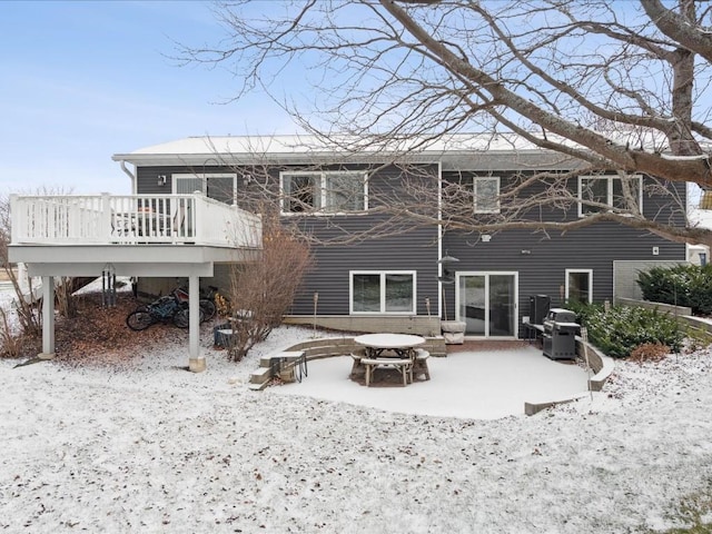 snow covered rear of property with a wooden deck