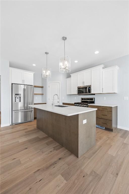 kitchen featuring sink, white cabinetry, an island with sink, and appliances with stainless steel finishes