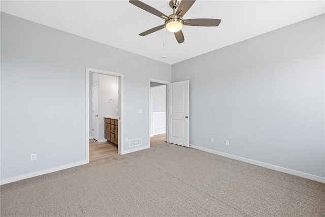 unfurnished bedroom featuring ensuite bathroom, ceiling fan, and light colored carpet